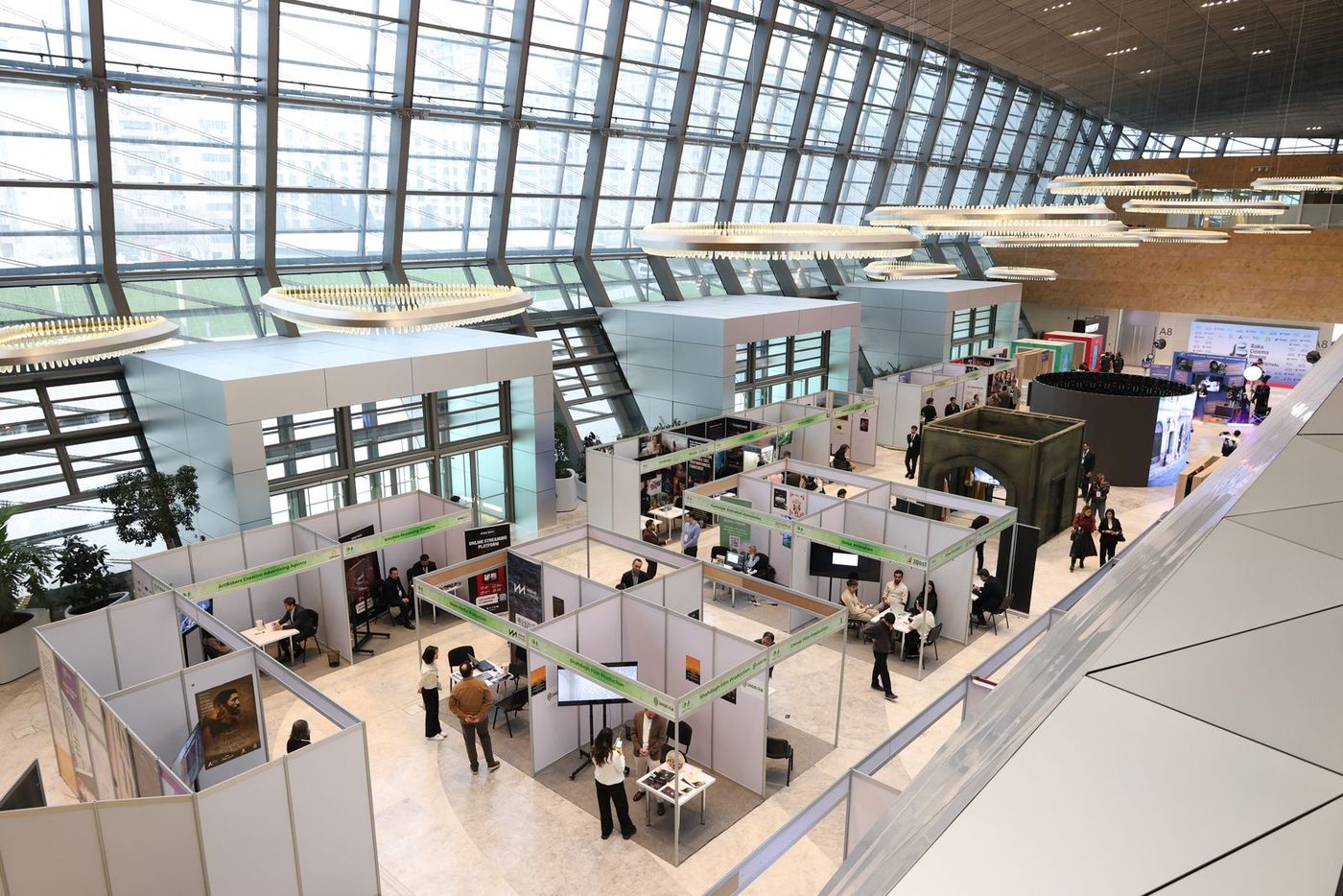 A busy exhibition hall with rows of stands and visitors