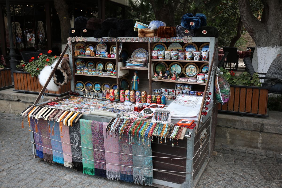 A market stall displaying handmade scarves and gifts at a busy outdoor market