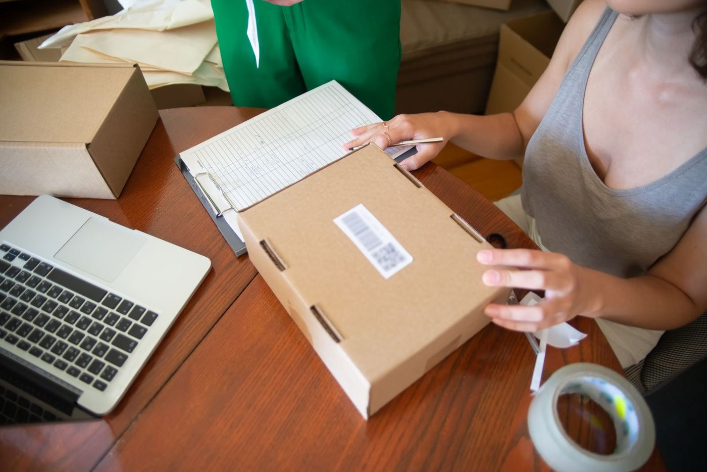 A small business owner packing customer orders at a home workshop bench