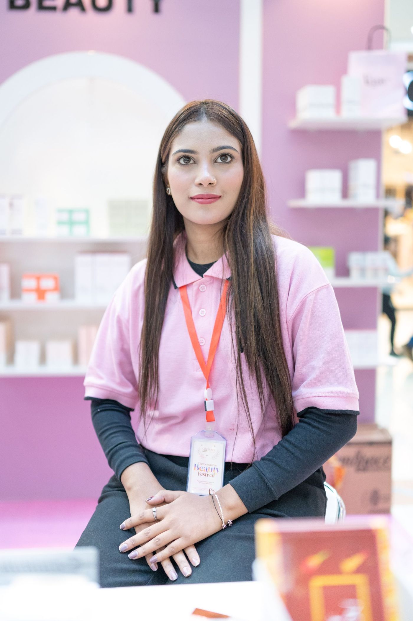 A staff member behind the counter of a small exhibition stand