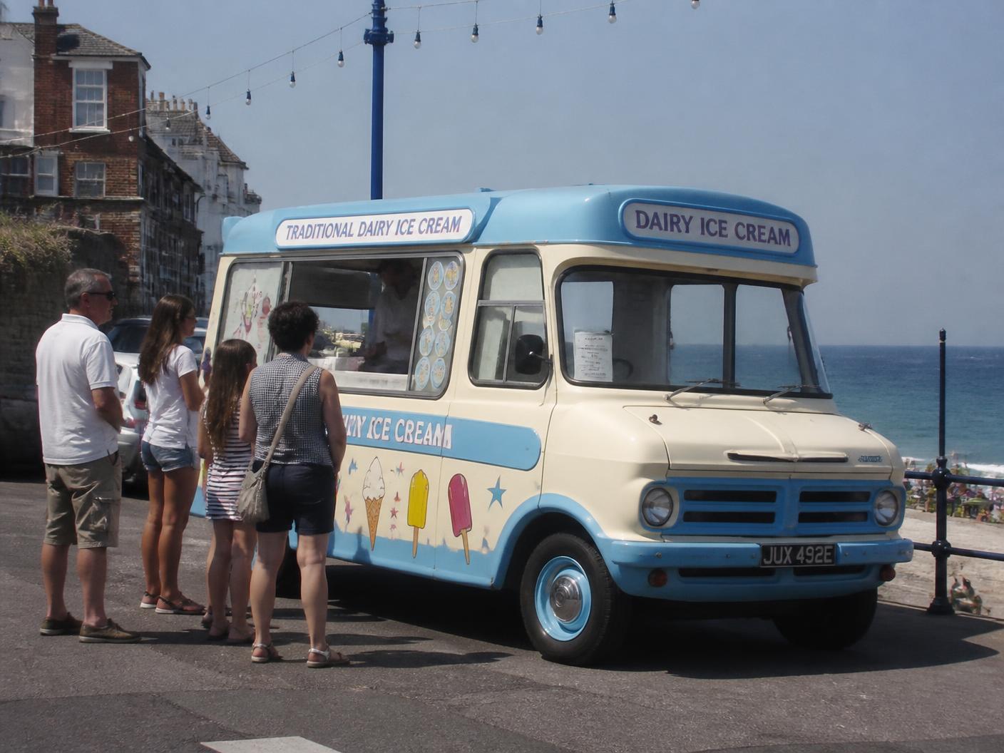 A traditional ice cream van serving customers by the seafront