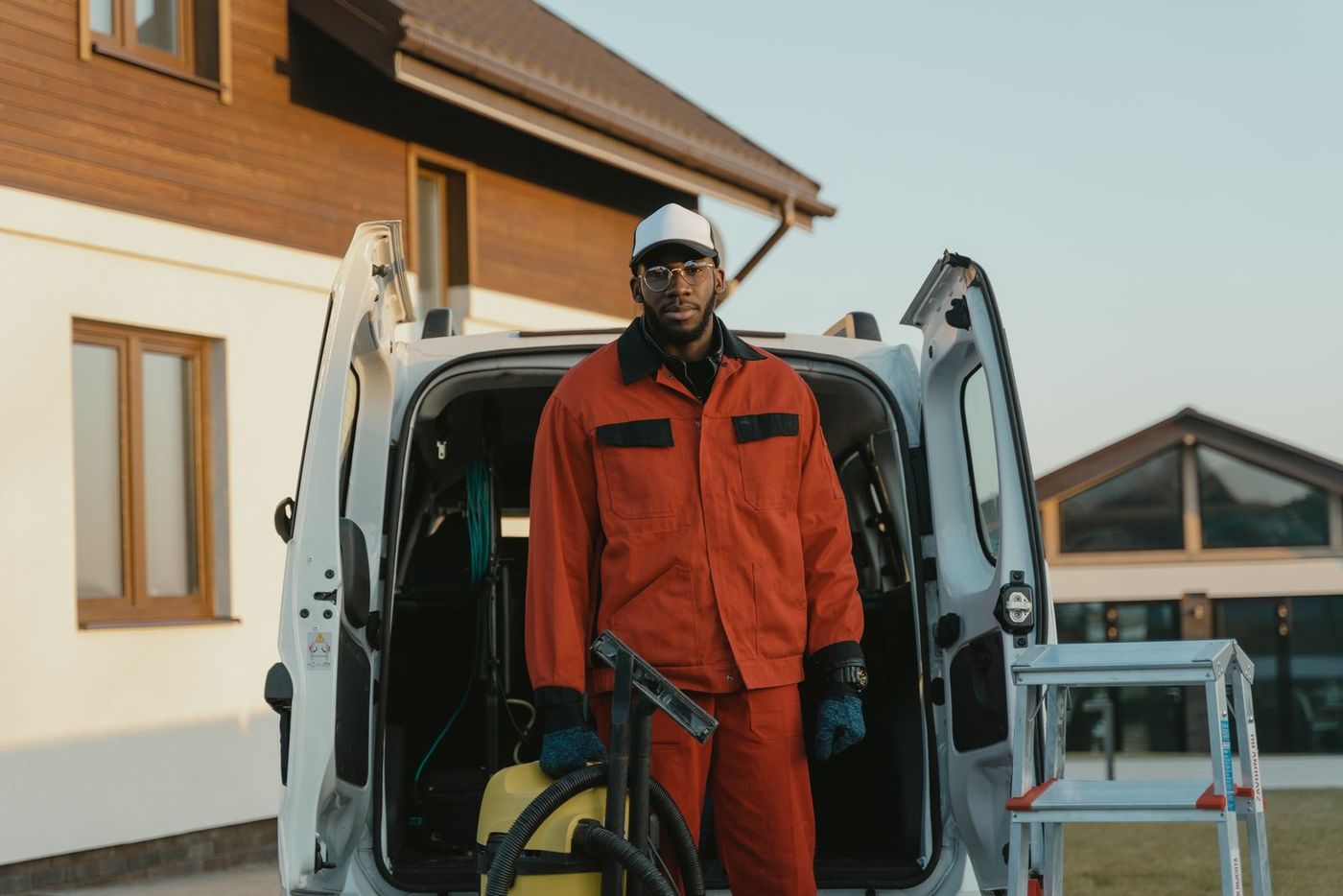 A tradesperson in hi-vis workwear loading equipment into a work van